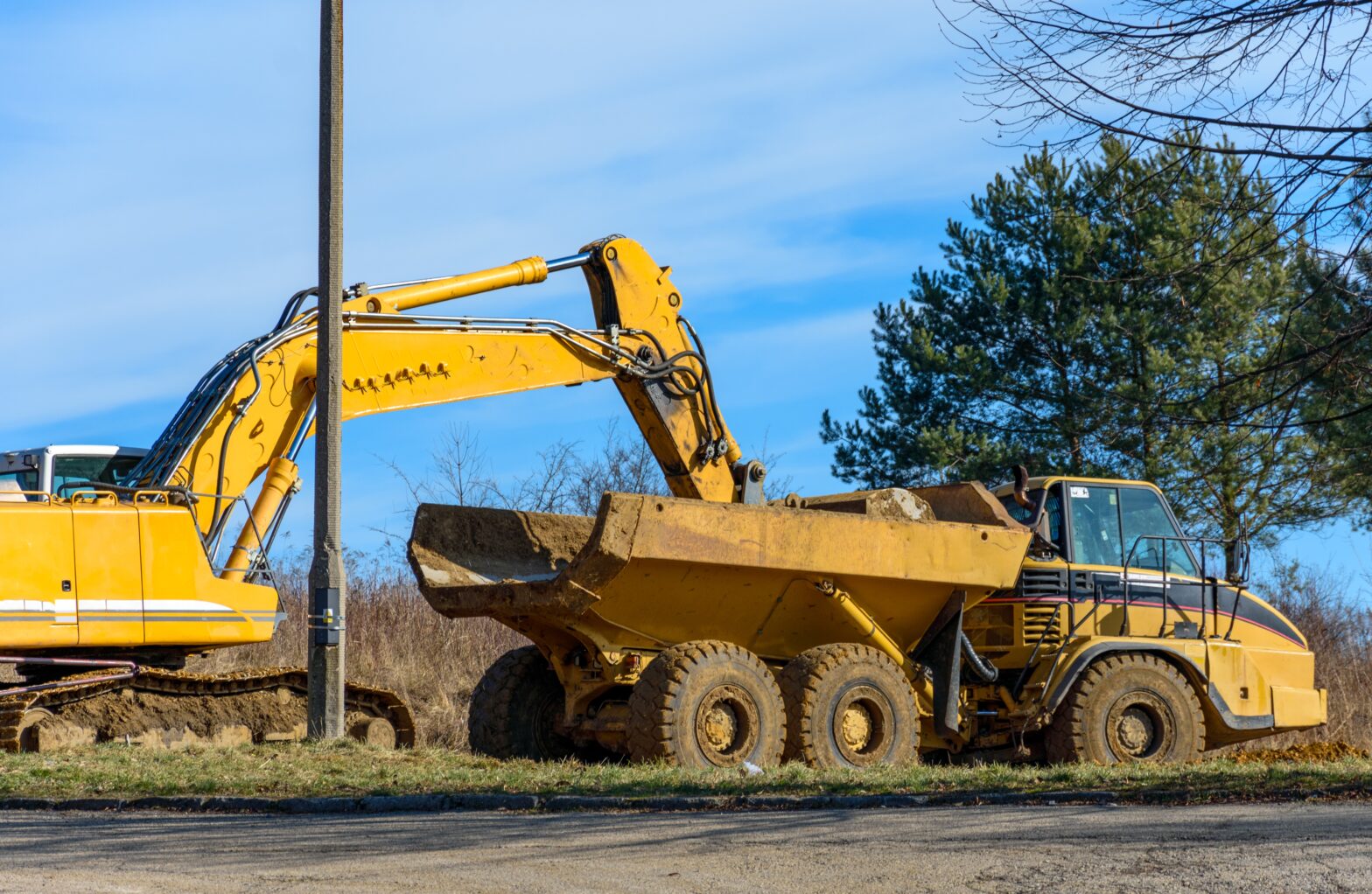 Bilden visar en grävskopa och en lastbil. Hydrauloljor och hydraulikoljor används till grävskopor och olika lyftanordningar för entreprenadmaskiner.